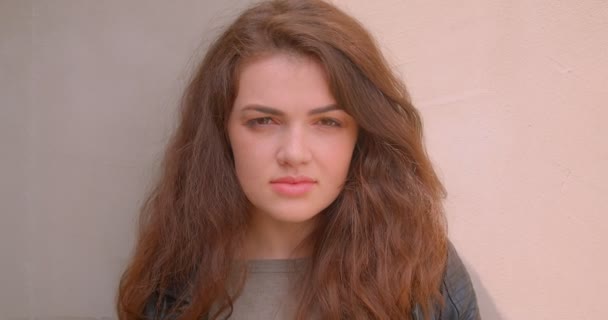 Portrét rozkošné brunetové dívky, která se dívala do kamery jako klidná a ponurná venku. — Stock video