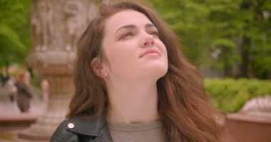 Kafkas esmer modelinin yakın çekim yeşil yağmurlu parkta yağmur tahmin şemsiye açılır.