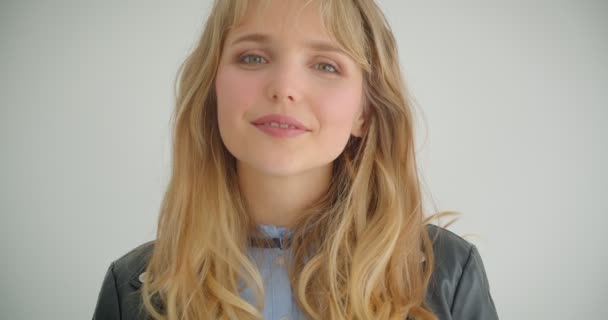 Cute blonde girl in leather jacket smiling prettily into camera isolated on white background. — Stock Video