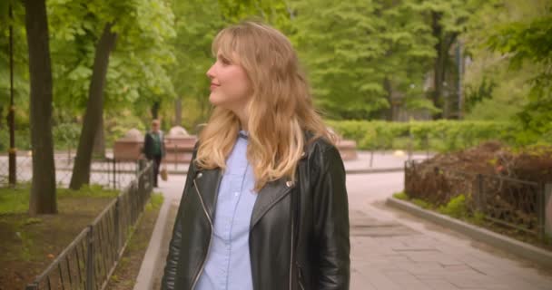 Mooie blanke blonde student staande in het groene park observeer de schoonheid van de natuur. — Stockvideo