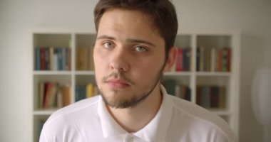 Kütüphanede kameraya bakan yakışıklı beyaz erkek Closeup portre
