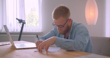Ofiste kapalı belge imzalayarak yetişkin kızıl saçlı kafkas işadamının closeup portre