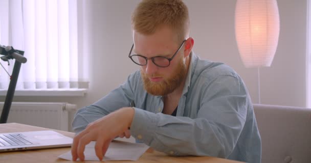 Retrato de close-up do empresário adulto caucasiano chefe em óculos assinando o documento dentro de casa no escritório — Vídeo de Stock