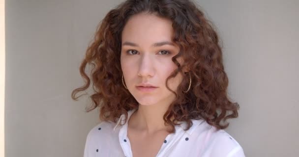 Zbliżenie portret młodego dość długowłosy kręcone kaukaski kobieta model patrząc uwodzicielsko w aparacie z tła na białym tle — Wideo stockowe