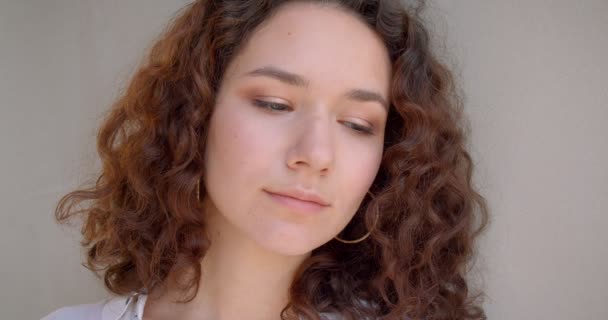 Retrato de close-up de jovem de cabelos longos encaracolado modelo feminino caucasiano sorrindo alegremente olhando para a câmera com fundo isolado no branco — Vídeo de Stock