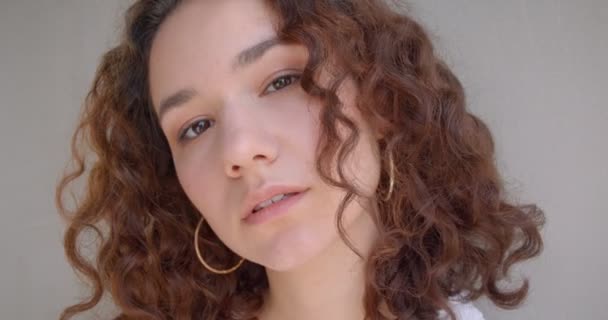 Closeup portrait of young sexy long haired curly caucasian female model looking at camera with background isolated on white — Stock Video