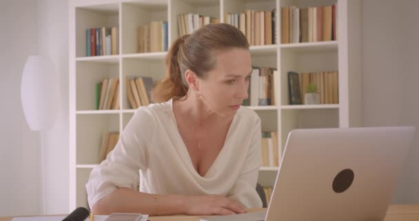 Zbliżenie portret starszej kaukaski brunetka bizneswoman o rozmowę wideo na laptopie w biurze w pomieszczeniu — Wideo stockowe