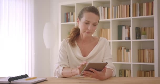 Primer plano retrato de anciana caucásica morena mujer de negocios utilizando la tableta y mostrando pantalla de croma verde a la cámara en la oficina en el interior — Vídeos de Stock