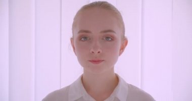 Beyaz dairede kapalı kamera bakarak genç güzel beyaz sarışın kadın yüz Closeup portre