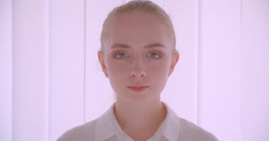 Beyaz daire de kapalı gülümseyen ifade ile kameraya bakarak genç güzel beyaz sarışın kadın yüz Closeup portre