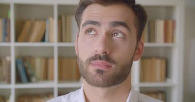 Yetişkin yakışıklı beyaz adam kamera Kütüphane kapalı düşünceli olmak görünümlü fotoğraf çekim portre