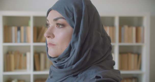 Retrato de close-up de jovem muçulmano atraente empresária em hijab olhando para a câmera sorrindo alegremente na biblioteca dentro de casa — Vídeo de Stock