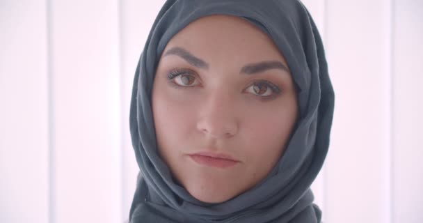 Zbliżenie Portret młodej arabskiej atrakcyjnej businesswoman w hidżab patrząc na kamerę w białym mieszkaniu w pomieszczeniu — Wideo stockowe