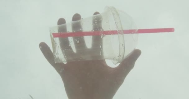 Close-up shoot van mannelijke hand gooien een plastic fles in de oceaan water — Stockvideo