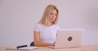 Ofiste Laptop kapalı kullanarak yetişkin beyaz sarışın işkadını portre kapatmak