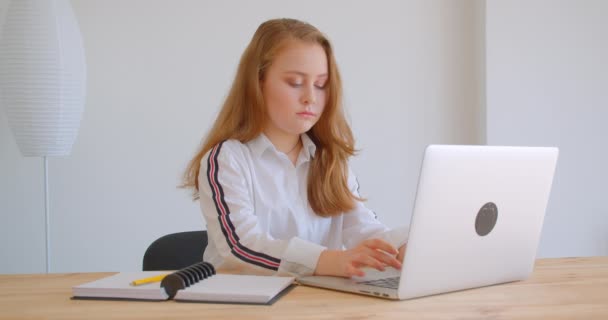 Retrato de close-up de jovem menina bonita caucasiana usando o latop dentro de casa no apartamento — Vídeo de Stock