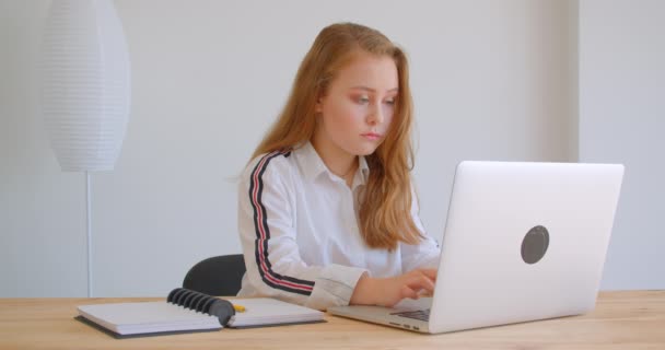 Latop을 사용하여 아파트에서 온라인으로 공부하는 젊은 예쁜 백인 소녀의 클로즈업 초상화 — 비디오