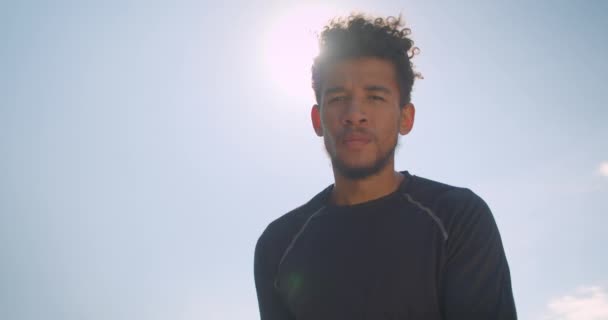 Close-up portret van jonge atletische Afro-Amerikaanse mannelijke basketbalspeler gooien een bal in een hoepel buitenshuis — Stockvideo