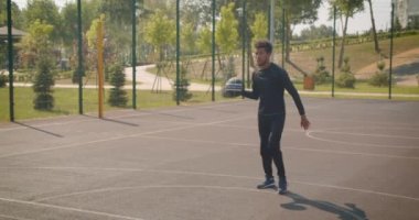 Genç yakışıklı Afrikalı Amerikalı erkek basketbol oyuncusu açık havada bir çember içine bir top atma portre, mahkeme