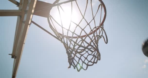 Retrato de primer plano de la pelota de baloncesto lanzada en un aro al aire libre en la cancha — Vídeos de Stock
