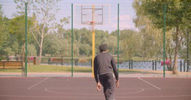 Kentsel şehir açık havada bir çember içine bir topu atma Genç yakışıklı Afrikalı Amerikalı erkek basketbol oyuncusu portre