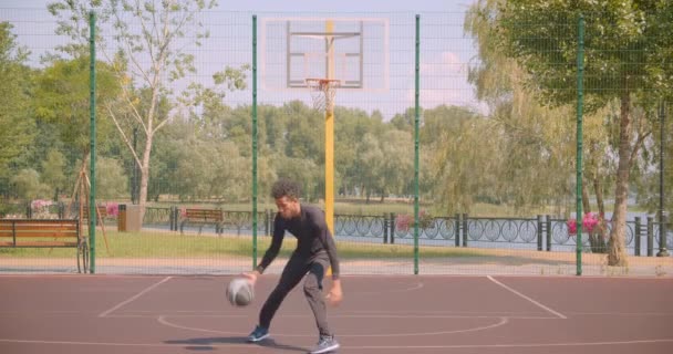 Retrato del jugador de baloncesto afroamericano deportivo lanzando una pelota en un aro en la cancha en la ciudad urbana al aire libre — Vídeos de Stock