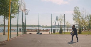 Sportif çekici Afrikalı Amerikalı erkek basketbol oyuncusu bir çember içine topu atma ve arka planda köprü ile kentsel şehir açık havada mahkemede hayal kırıklığına başarısız portresi