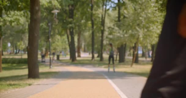Närbild porträtt av unga starka afroamerikanska manliga löpare jogging i parken utomhus — Stockvideo