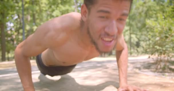 Close-up portret van jonge sterke shirtless Afro-Amerikaanse man het maken van push-ups in het Park buitenshuis — Stockvideo