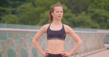 Kentsel şehir açık havada köprü üzerinde spor sporu ayakta genç güzel sportif kadın koşucu duran closeup ön görünüm portre