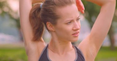 Genç güzel sportif Fitness kız kentsel şehir açık havada parkta kollarını germe closeup portre