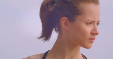 Açık havada arka planda mavi gökyüzü ile belirlenen ileriye bakarak spor genç güzel kadın koşucu portre closeup