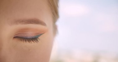 Güzel açık havada kamera görünümlü göz ile genç Sevimli beyaz kadın yüz closeup yarım yüz portre