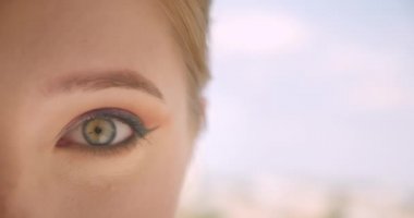 Açık havada heyecanlı olmak kamera görünümlü göz ile genç güzel beyaz kadın yüz closeup yarım yüz portre