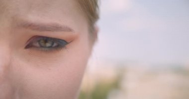 Açık havada hayal kırıklığı ile kamera görünümlü göz ile genç Sevimli beyaz kadın yüz closeup yarım yüz portre