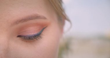 Genç büyüleyici beyaz kadın yüz closeup yarım yüz portre göz kamera baştan çıkarıcı bir kaş açık havada yükselterek bakıyor