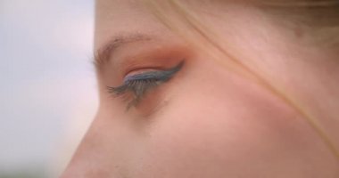 Açık havada gülümseyen ifade ile kamera görünümlü göz ile genç neşeli beyaz kadın yüz closeup profil yarım yüz portre
