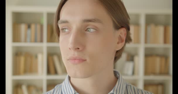 Closeup portré fiatal vonzó kaukázusi Férfi diák várja a könyvtárban beltéri — Stock videók