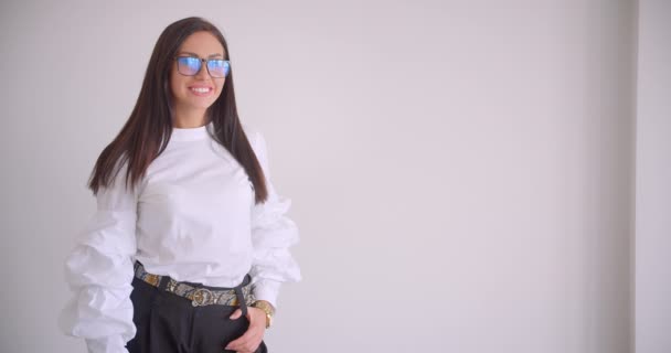 Closeup portrait of young pretty caucasian businesswoman in glasses looking at camera smiling happily in the white apartment — Stock Video