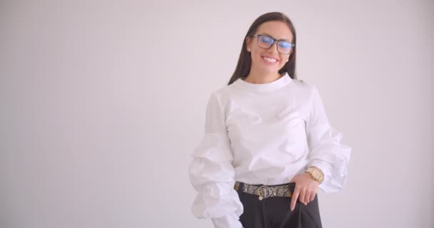 Gros plan portrait de jeune jolie femme d'affaires caucasienne en lunettes regardant la caméra souriant joyeusement debout dans l'appartement blanc — Video