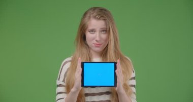 Tableti kullanarak ve kameraya mavi ekran gösteren genç güzel beyaz kadın closeup çekim neşeyle gülümseyerek