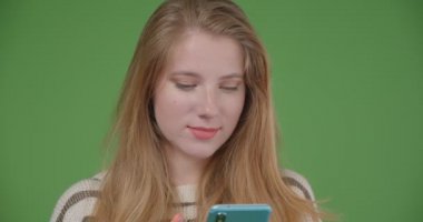 Telefonu kullanarak ve kameraya mavi ekran gösteren genç güzel beyaz kadın Closeup çekim mutlu gülümseyerek