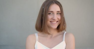 Saç halkaları ve glitter makyaj dans ile genç güzel beyaz kadın Closeup ateş mutlu kapalı beyaz odada kamera bakarak