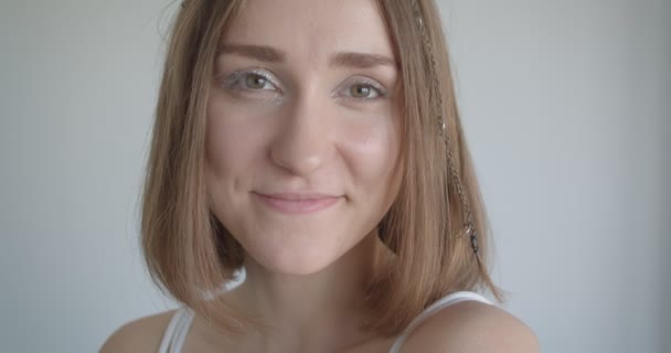 Close-up shoot van jonge mooie Kaukasische vrouw met haar ringen en glitter make-up glimlachend vrolijk kijken naar de camera in de witte kamer binnenshuis — Stockvideo