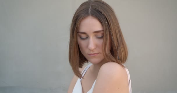 Close-up zijaanzicht schieten van jonge mooie blanke vrouw met haar ringen en glitter make-up poseren voor de camera in de witte kamer binnenshuis — Stockvideo