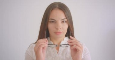 Gözlüklü genç beyaz beyaz kız öğrencinin beyaz üzerine izole arka planlı kameraya bakan yakın çekim portresi