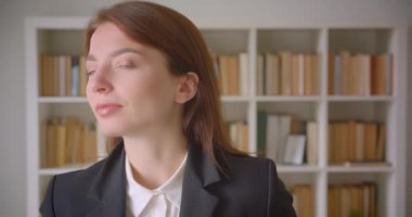 Kütüphanede kameraya bakan genç kafkas iş kadınının yakın çekim portresi