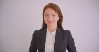 Beyaz dairede mutlu bir şekilde gülümseyen kameraya bakan beyaz beyaz iş kadınının yakın çekim portresi