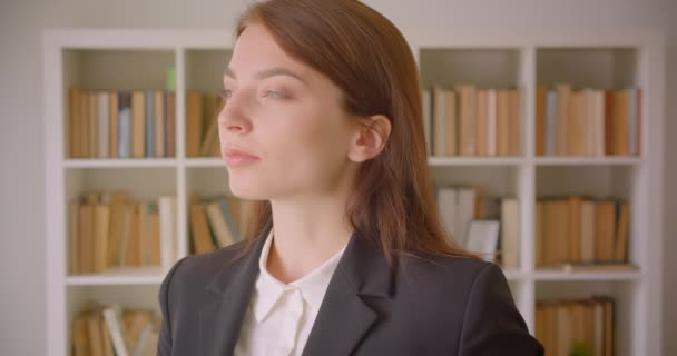 Крупный план портрета молодой успешной кавказской предпринимательницы, смотрящей в библиотеку на камеру — стоковое видео