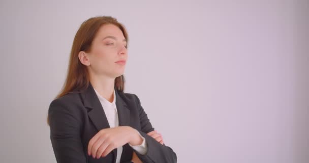 Zbliżenie Portret młodej kaukaski biznesmen patrząc na aparat z rękami przekreślone klatki piersiowej w białym biurze — Wideo stockowe